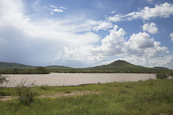 Stock Pond in Southeast Arizona with storm clouds in sky